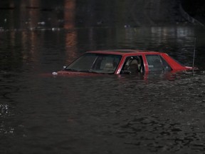 An empty vehicle is surrounded by floodwaters on a road in Oakland, Calif., Wednesday, Jan. 4, 2023.
