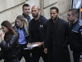 Andrew Tate, third right, and his brother Tristan, second right, are brought by police officers to the Court of Appeal, in Bucharest, Romania, Tuesday, Jan.10, 2023.