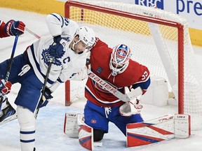 Montreal Canadiens goaltender Sam Montembeault stops Toronto Maple Leafs John Tavares as Canadiens David Savard defends during the first period Saturday.