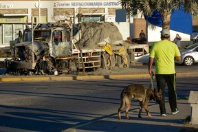 A man passes by a burnt truck on a street a day after an operation to arrest the son of Joaquin “El Chapo” Guzman, Ovidio Guzman, in Culiacan, Sinaloa state, Mexico, on Jan. 6, 2023. Mexican security forces captured a son of jailed drug kingpin Joaquin “El Chapo” Guzman, scoring a high-profile win in the fight against powerful cartels. Ovidio Guzman, who was arrested in the northwestern city of Culiacan, is accused of leading a faction of his father’s notorious Sinaloa cartel, Defense Minister Luis Cresencio Sandoval told reporters. (Photo by JUAN CARLOS CRUZ/AFP via Getty Images)