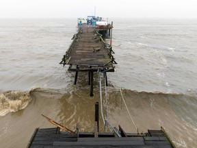A damaged pier is split in Capitola, California on Jan. 9, 2023. A massive storm called a "bomb cyclone" by meteorologists has arrived and is expected to cause widespread flooding throughout the state.