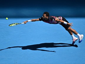 Canada's Felix Auger-Aliassime hits a return against Argentina's Francisco Cerundolo during their men's singles match on day five of the Australian Open tennis tournament in Melbourne on January 20, 2023.