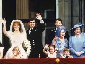 Prince Andrew, the Duke of York and his wife Sarah Ferguson, the Duchess of York, wave to crowds July 23, 1986 from the balcony of Buckingham Palace in London while Queen Elizabeth II and Queen Mother look on.