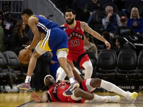 Golden State Warriors guard Jordan Poole loses the ball out of bounds as he is defended by Toronto Raptors forward Precious Achiuwa (5) and guard Fred VanVleet (23) during the third quarter at Chase Center on Friday night.