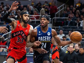 Indiana Pacers guard Buddy Hield passes the ball while Toronto Raptors guard Gary Trent Jr. defends in the second  half at Gainbridge Fieldhouse.