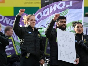 Ambulance workers hold placards outside their Waterloo station, amid a strike due to a dispute with the government over pay, in London January 11, 2023.