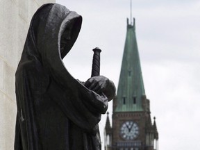 The Peace Tower on Parliament Hill is seen behind the justice statue outside the Supreme Court of Canada in Ottawa, Monday June 6, 2016. THE CANADIAN PRESS/Adrian Wyld