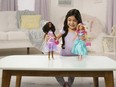 This image released by Mattel shows a child playing with Teresa, a My First Barbie deluxe set, new dolls made specifically for children as young as 3.