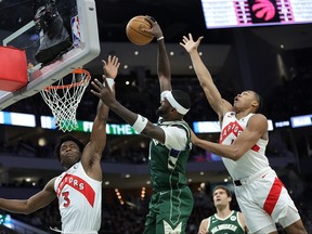 Bucks’ Bobby Portis (middle) drives to the basket against OG Anunoby (left) and Scottie Barnes during the first half at Fiserv Forum in Milwaukee last night.