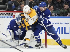 Maple Leafs' Morgan Rielly (right) tries to clear Nashville Predators' Nino Niederreiter from out in front of Leafs goaltender Matt Murray during the second period in Toronto on Wednesday, Jan. 11, 2023.