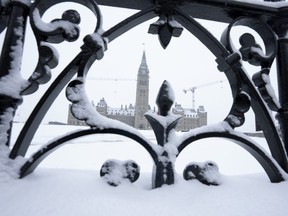 Snow covers a fence surrounding Parliament Hill, Friday, January 20, 2023 in Ottawa.