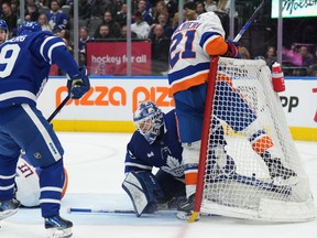 New York Islanders centre Kyle Palmieri crashes into Maple Leafs goaltender Ilya Samsonov as Leafs' Pontus Holmberg and Islanders' Anders Lee battle during the third period in Toronto on Monday Jan. 23, 2023.