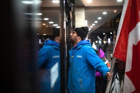 Protesters yell at the door of a hotel where Prime Minister Justin Trudeau is staying during the Liberal Cabinet retreat in downtown Hamilton, Ont., on Tuesday, January 24, 2023. THE CANADIAN PRESS/Nick Iwanyshyn