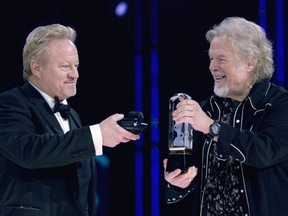 Randy Bachman holds the Juno as Robbie Bachman videotapes a closeup of the trophy after being inducted into the Canadian Music Hall of Fame at the Juno Awards in Winnipeg, March 30, 2014.