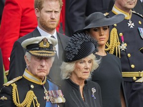 King Charles III, from bottom left, Camilla, the Queen Consort, Meghan, Duchess of Sussex and Prince Harry watch as the coffin of Queen Elizabeth II is placed into the hearse following the state funeral service in Westminster Abbey in central London Monday Sept. 19, 2022.