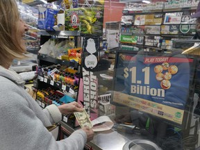 A Mega Millions customer purchases her tickets for the estimated jackpot of $1.1 Billion at the Fuel On Convenience Store in Pittsburgh, Monday, Jan. 9, 2023.