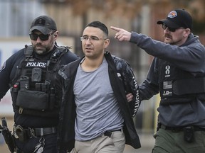 Solomon Pena, centre, a Republican candidate for New Mexico House District 14, is taken into custody by Albuquerque Police officers, Monday, Jan. 16, 2023, in southwest Albuquerque, N.M.
