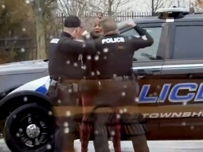 This screen grab made from video shows Butler Township officers Sgt. Tim Zellers, left, and Todd Stanley, right, restrain and arrest Latinka Hancock outside a McDonald's restaurant in Butler Township, Ohio, on Monday, Jan. 16, 2023.