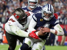 Dallas Cowboys quarterback Dak Prescott, right, rushes the ball for a touchdown against the Tampa Bay Buccaneers defensive end Akiem Hicks in the first half during the wild card game at Raymond James Stadium in Tampa, Fla., Jan. 16, 2023.
