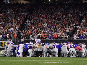 Buffalo Bills players huddle and pray after teammate Damar Hamlin #3 collapsed on the field after making a tackle against the Cincinnati Bengals during the first quarter at Paycor Stadium.