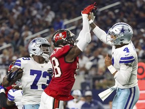 Dallas Cowboys quarterback Dak Prescott hits his hand against Tampa Bay Buccaneers linebacker Shaquil Barrett while throwing during the fourth quarter at AT&T Stadium.