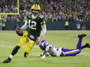 Green Bay Packers quarterback Aaron Rodgers (12) scores a touchdown against Minnesota Vikings linebacker Brian Asamoah II (33) in the fourth quarter of their game at Lambeau Field Jan 1, 2023 in Green Bay, Wisconsin.