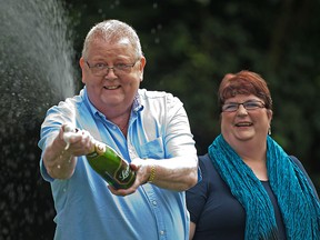 Colin Weir (L) and his wife Chris pose for pictures during a photocall in Falkirk, Scotland, on July 15, 2011, after winning a record GBP161m (184m euros/259m USD) in the EuroMillions Lottery, on July 15, 2011.