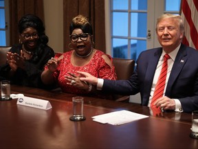 U.S. President Donald Trump, right, listens as Lynette "Diamond" Hardaway, left, and Rochelle "Silk" Richardson praise him during a news conference and meeting with African American supporters in the Cabinet Room at the White House Feb. 27, 2020 in Washington, D.C.