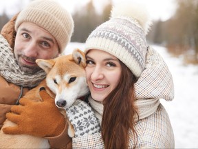 Portrait of Happy Adult Couple with Dog in Winter