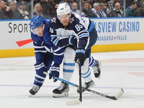 Pierre-Luc Dubois of the Winnipeg Jets battles for control of the puck against Alexander Kerfoot of the Toronto Maple Leafs during an NHL game at Scotiabank Arena on March 31, 2022 in Toronto, Ontario, Canada.