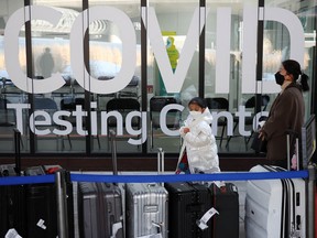 A Chinese girl looks at luggage standing outside the COVID-19 testing centre upon her arrival at the Incheon International Airport in Incheon, South Korea, January 4, 2023.