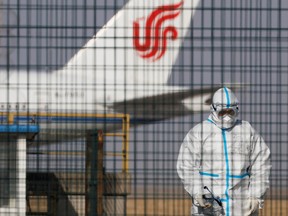 A worker in a protective suit walks near an Air China plane at Beijing Capital International in Beijing, China January 6, 2023.