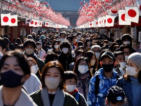 Visitors wearing protective face masks walk under decorations for the New Year at Nakamise street leading to Senso-ji temple at Asakusa district, a popular sightseeing spot, amid the coronavirus disease (COVID-19) pandemic, in Tokyo, Japan, January 9, 2023.