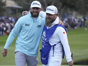 Max Homa (left) reacts with caddy Joe Greiner after the final round of the Farmers Insurance Open golf tournament at Torrey Pines Municipal Golf Course - South Course.