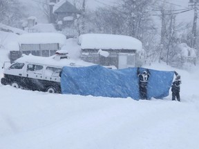 Police officers try to transport victims found at an accident site following an avalanche the previous day, in the village of Otari in Nagano Prefecture, central Japan, January 30, 2023.