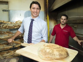 Liberal leader Justin Trudeau shows off a loaf of fresh bread just removed from an oven during a campaign stop at a general store Monday, September 28, 2015 in Toronto. THE CANADIAN PRESS/Paul Chiasson