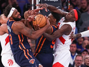 New York Knicks centre Mitchell Robinson (23) and guard RJ Barrett (9) battle for a rebound against Toronto Raptors forward Pascal Siakam (43) and forward Scottie Barnes (4) during the second half at Madison Square Garden on Monday afternoon.