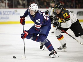 Team USA forward Logan Cooley skates the puck ahead of Philipp Bidoul of Germany during the quarterfinal game of the 2023 IIHF World Junior Championship at Avenir Centre in Moncton, N.B., Monday, Jan. 2, 2023.