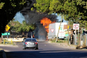 A vehicle is seen near burning buses which were set on fire by members of a drug gang following the detention of Mexican drug gang leader Ovidio Guzman, a son of incarcerated kingpin Joaquin “El Chapo” Guzman. Ovidio Guzman was arrested by Mexican authorities, in Culiacan, Mexico, Jan. 5, 2023.