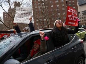 NYSNA nurses hold signs as they drive up Madison Avenue during a strike at Mount Sinai Hospital in New York City, U.S. January 9, 2023. REUTERS/Andrew Kelly