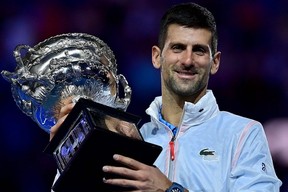 Novak Djokovic celebrates with the Norman Brookes Challenge Cup trophy following his victory against Stefanos Tsitsipas in the men’s singles final match of the Australian Open in Melbourne, Sunday, Jan. 29, 2023.