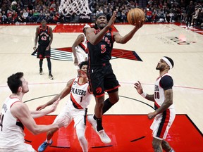 Raptors’ Precious Achiuwa drives to the basket past Trail Blazers shooting guard Anfernee Simons on Saturday in Portland. Achiuwa has another good game in the Raptors’ victory.