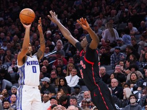 Sacramento Kings shooting guard Malik Monk (0) scores a three point basket against Toronto Raptors center Chris Boucher (25) during the fourth quarter at Golden 1 Center.