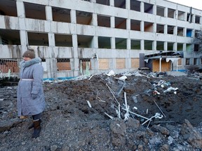 A woman stands at the site of a missile strike that occurred overnight, as Russia's attack on Ukraine continues, in Kramatorsk, Sunday, Jan. 8, 2023.