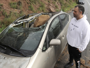 Owner Maurice Henao looks at the small boulder resting in his vehichle parked along the Pacific Coustal Highway in Malibu, California, Jan.10, 2023.