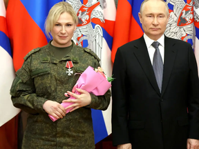 Russian President Vladimir Putin attends a ceremony to award military orders and medals to service members involved in Russia-Ukraine conflict, at the headquarters of the Southern Military District in Rostov-on-Don, Russia, Dec. 31, 2022. Observers are trying to figure out who the mystery blond is who appears at numerous Putin photo ops.