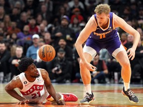 Raptors forward Thaddeus Young (21) and Phoenix Suns center Jock Landale (11) go after a loose ball during the second half at Footprint Center on Monday night.