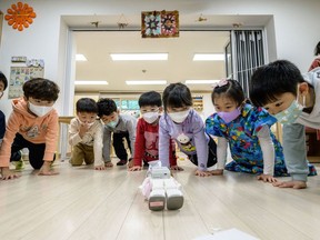 Young students do push ups with a robot in Seoul.