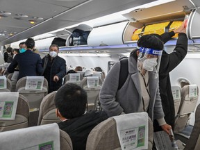 A passenger wearing a face shield and mask boards a domestic flight at Shanghai Pudong International Airport in Shanghai on January 3, 2023.