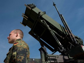 In this file photo taken on March 25, 2014 German soldiers stand to attention in front of a German Patriot missile launcher at the Gazi barracks in Kahramanmaras, southern Turkey on March 25, 2014.
